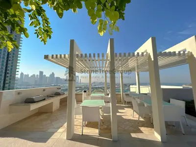 a patio with tables and chairs on the roof of a building at StoneTree - New Luxury Apartment with Private Beach in Dubai