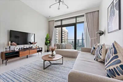 a living room with a couch and a tv at StoneTree - New Luxury Apartment with Private Beach in Dubai