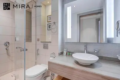 a bathroom with a sink and a toilet and a mirror at Mira Holiday Homes - Furnished 1 bedroom in Paramount Tower B in Dubai