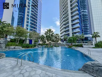 a swimming pool in the middle of two tall buildings at Mira Holiday Homes - Furnished 1 bedroom in Paramount Tower B in Dubai
