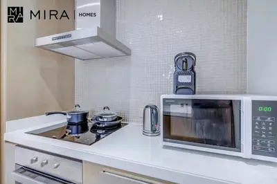 a microwave oven and a stove in a kitchen at Mira Holiday Homes - Furnished 1 bedroom in Paramount Tower B in Dubai