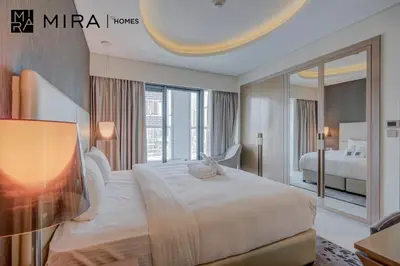 a bedroom with a large bed and a large mirror at Mira Holiday Homes - Furnished 1 bedroom in Paramount Tower B in Dubai