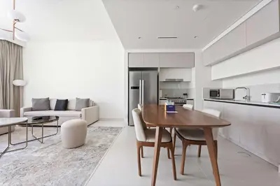 a kitchen and living room with a wooden table and chairs at Silkhaus The Marina View 2BDR Dubai Harbour in Dubai
