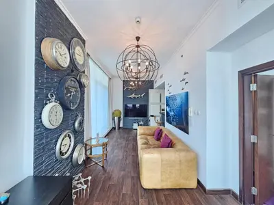a living room with a couch and clocks on the wall at Nice view apartment in Botanica Tower Dubai Marina in Dubai