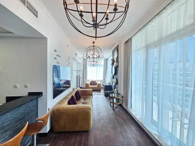 a living room with a couch and a chandelier at Nice view apartment in Botanica Tower Dubai Marina in Dubai
