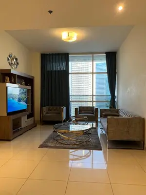 a living room with a couch and a tv at Spacious Flat in Dubai Downtown in Dubai