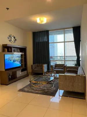 a living room with a couch and a television at Spacious Flat in Dubai Downtown in Dubai