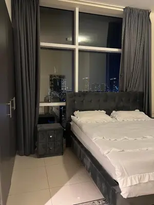 a bedroom with a large bed and a window at Spacious Flat in Dubai Downtown in Dubai