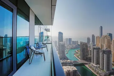 a balcony with two chairs and a view of a city at NEW Luxe 3BR in Vida Marina w/ Breathtaking Views in Dubai