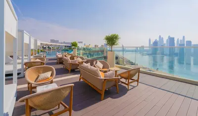 a row of chairs and tables on a balcony at Luxury Studio, Seven Palm Residence-Palm Jumeirah in Dubai