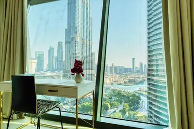 a desk in a room with a view of a city at FIRST CLASS 3BR with full BURJ KHALIFA and FOUNTAIN VIEW in Dubai