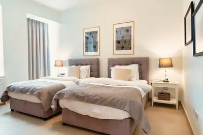 a bedroom with two beds and two lamps in it at FIRST CLASS 3BR with full BURJ KHALIFA and FOUNTAIN VIEW in Dubai