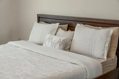 a bed with white sheets and pillows at Stunning 1 BR Apartment in Dubai Marina in Dubai