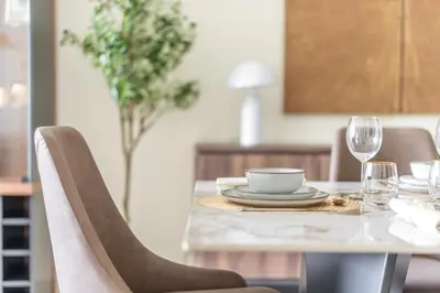 a dining room table with a plate and glasses at GuestReady - Glamourous living in Palm Jumeirah in Dubai