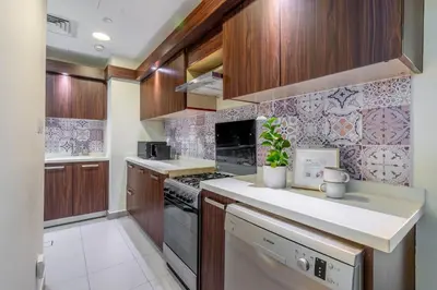 a kitchen with wooden cabinets and a stove top oven at GuestReady - Glamourous living in Palm Jumeirah in Dubai
