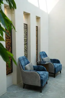 two chairs and a couch in a room at The Biltmore Hotel Villas, Dubai in Dubai