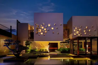 a building with a lot of windows on it at night at The Biltmore Hotel Villas, Dubai in Dubai