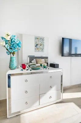 a white dresser with a vase on top of it at Dubai Dreamland 1BR for 4, King Bed, Pool, Sauna, Gym, Free Parking in Dubai