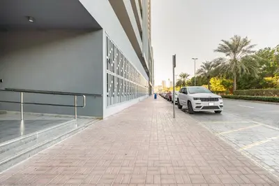a white truck parked next to a building at Dubai Dreamland 1BR for 4, King Bed, Pool, Sauna, Gym, Free Parking in Dubai