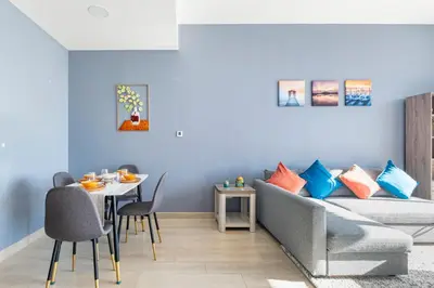 a living room with a couch and a table at Dubai Dreamland 1BR for 4, King Bed, Pool, Sauna, Gym, Free Parking in Dubai