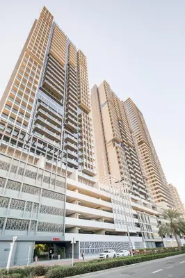 two tall buildings are standing next to a street at Dubai Dreamland 1BR for 4, King Bed, Pool, Sauna, Gym, Free Parking in Dubai