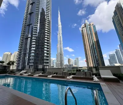 a swimming pool in a city with tall buildings at Burj Khalifa view - Modern 1BDR apartment in Dubai