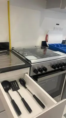 a kitchen with a stove and utensils in a drawer at Best Offer in Dubai hotel apartment damac hills 2 in Dubai