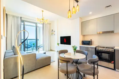 a living room with a couch and a table at Modern 1 BR with Sea View - Minutes to Dubai Mall, Downtown Dubai in Dubai