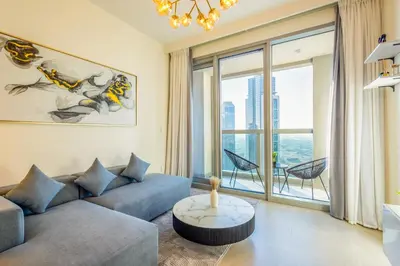 a living room with a couch and a table at Modern 1 BR with Sea View - Minutes to Dubai Mall, Downtown Dubai in Dubai