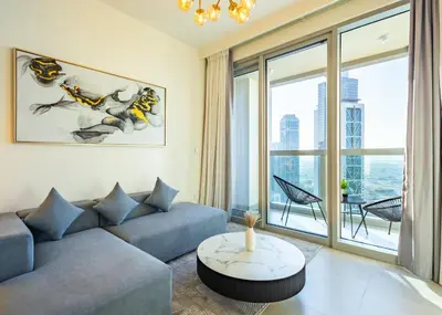 a living room with a couch and a large window at Modern 1 BR with Sea View - Minutes to Dubai Mall, Downtown Dubai in Dubai