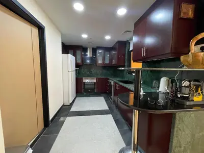 a kitchen with wooden cabinets and a white refrigerator at AMWAJ JBR Walk Beachfront Apt in Dubai