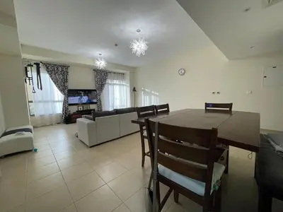 a dining room and living room with a table and chairs at AMWAJ JBR Walk Beachfront Apt in Dubai