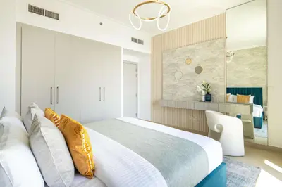 a bedroom with a large bed and a chair at Frank Porter - Burj Vista 1 in Dubai