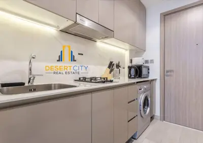 a kitchen with a sink and a washing machine at Azizi Riviera 7 - Meydan City, Dubai in Dubai