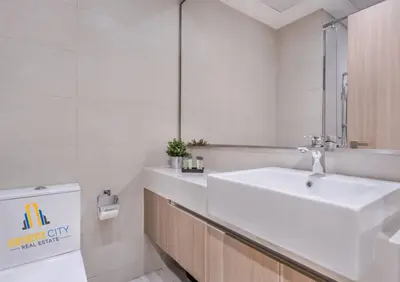 a white bathroom with a sink and a mirror at Azizi Riviera 7 - Meydan City, Dubai in Dubai