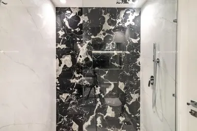 a bathroom with a black and white marble shower stall at The Smart Concierge - Reehan 8 in Dubai