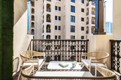 a table and chairs on a balcony with a building at The Smart Concierge - Reehan 8 in Dubai