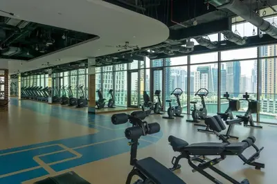a gym with a lot of treadmills and exercise bikes at 1BDR in Marina Gate Skylineview in Dubai