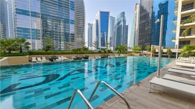 a swimming pool in a city with tall buildings at Zada Tower , near to Burj Khalifa NYE fireworks in Dubai