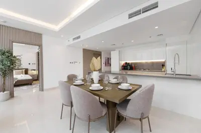 a kitchen and dining room with a wooden table and chairs at Business Bay Exquisite Living Experience-Suiteable in Dubai