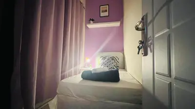 a room with a bed with a purple wall at Peaceful Partition Room Near Mall of the Emirates in Dubai