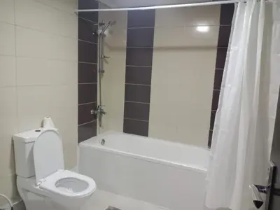 a bathroom with a toilet and a tub and a shower at Wow Partition Room In Barsha 1 Near MOE Metro in Dubai