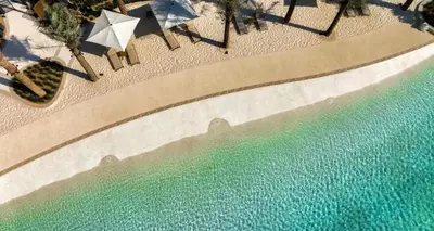 an overhead view of a swimming pool with umbrellas and water at Luxury 1BR Retreat @ Vida Residences - Creek Beach in Dubai