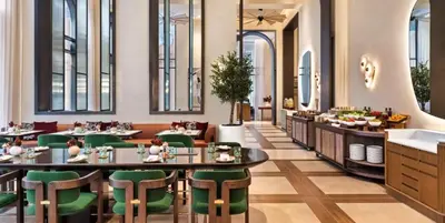 a dining room with tables and green chairs at Luxury 1BR Retreat @ Vida Residences - Creek Beach in Dubai