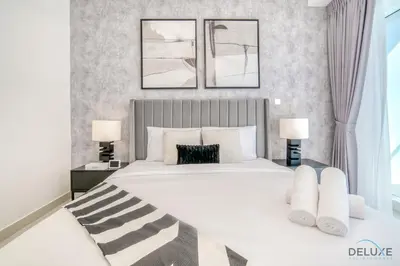 a bedroom with a large white bed with two lamps at Wondrous 1BR at DAMAC Heights Dubai Marina by Deluxe Holiday Homes in Dubai