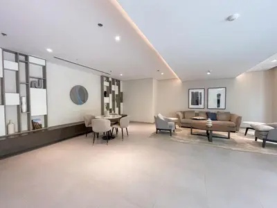a living room with a couch and a table and chairs at Elegant apartment in Dubai Creek Harbour in Dubai