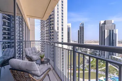 a balcony with chairs and a table and some buildings at Elegant apartment in Dubai Creek Harbour in Dubai