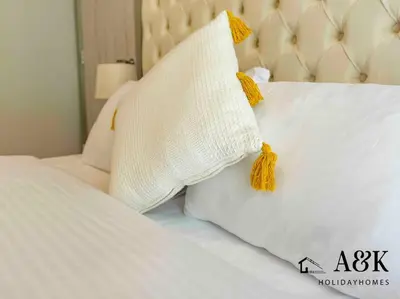 a bed with two white pillows with yellow bow ties at Near Burj Khalifa NYE Brand New Cozy 1BR Business Bay in Dubai