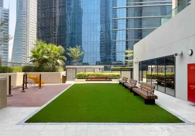 a park with benches and a green lawn at Near Burj Khalifa NYE Brand New Cozy 1BR Business Bay in Dubai