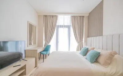 a hotel room with a bed and a television at Studio with pool and private beach access on Palm Jumeirah in Dubai